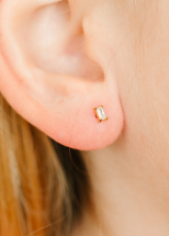 A person wearing the Trinity Ball Screw Back Earrings