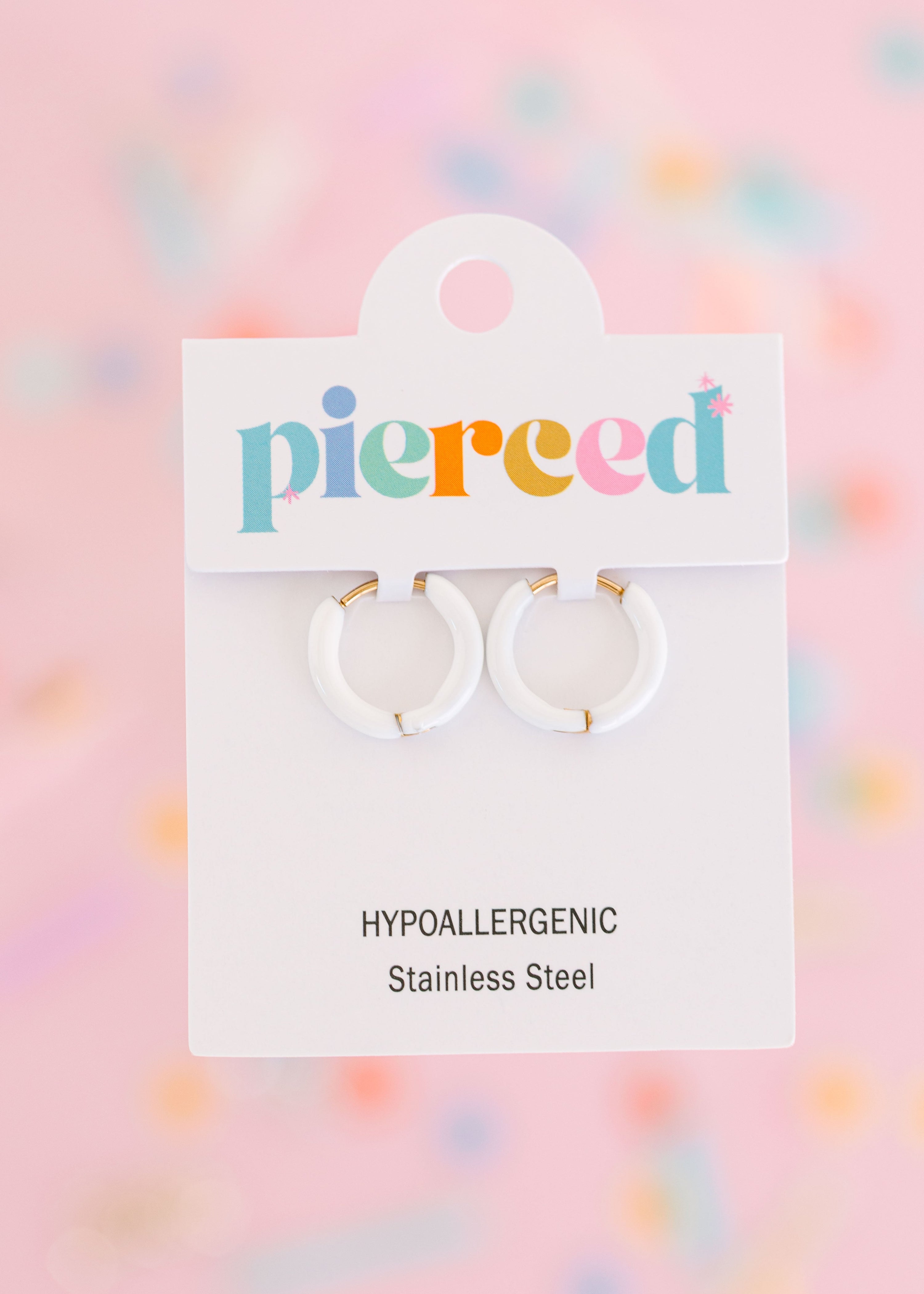 White hoop earrings on their packaging card with a colorful blurred background