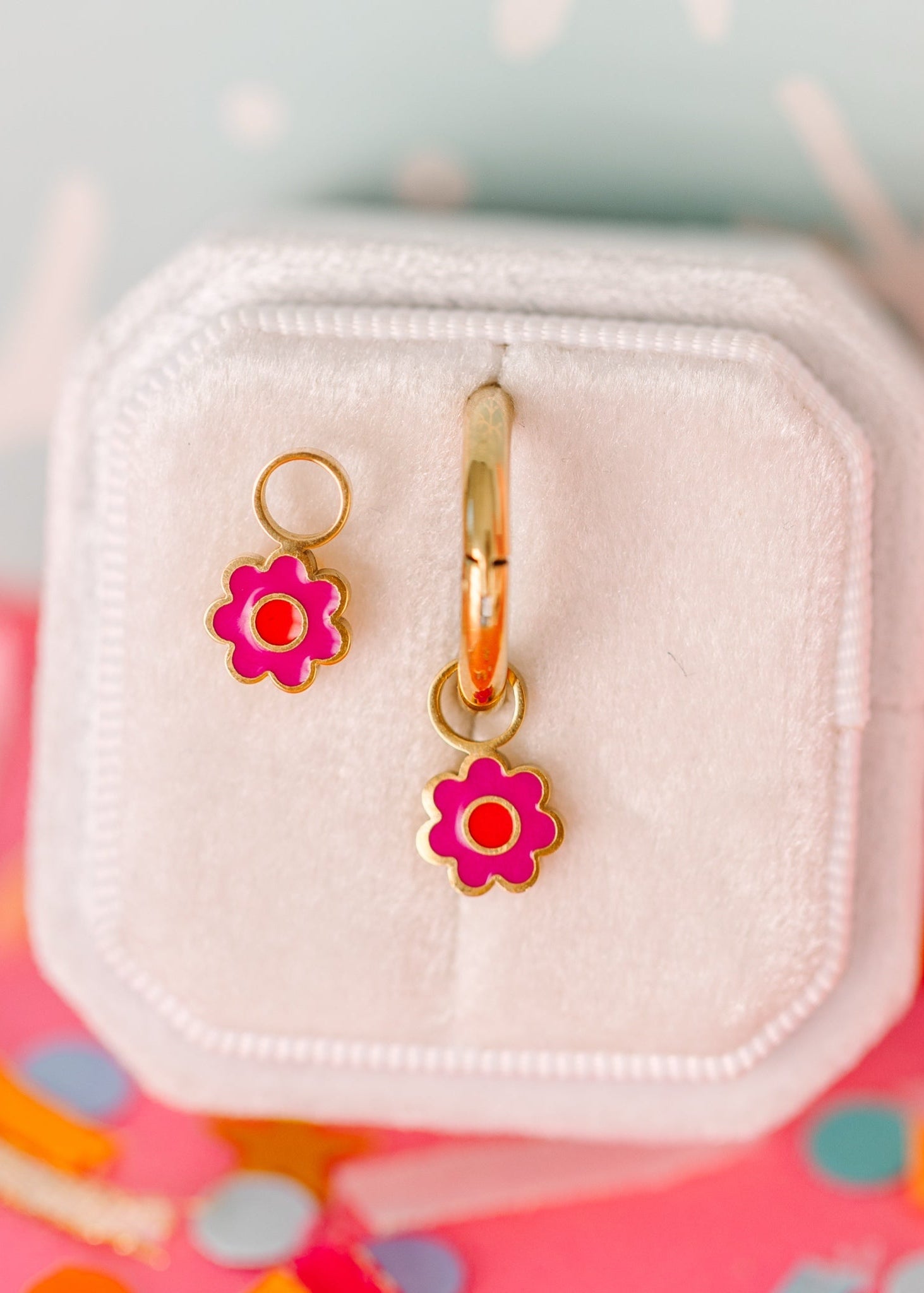 Hot pink flower with orange center connected to hoop to hang on huggies